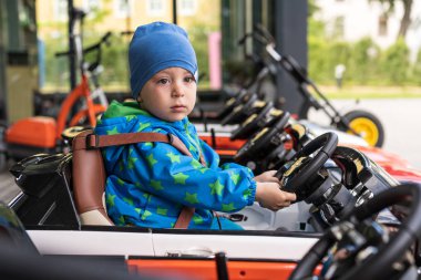 küçük çocuk iki yaşında bir çocuğun arabasında mutsuz oturan, emniyet kemeri takan