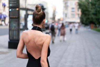 Sokakta poz veren çok güzel bir mankenin yakın çekim. Modaya uygun bir yön. İlginç bir saç modeli, makyaj ve orijinal küpe.