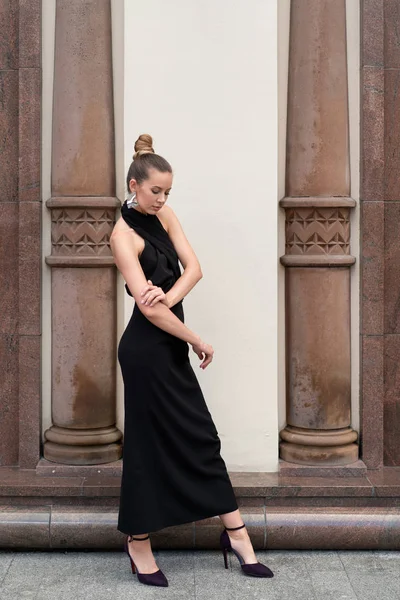 model european girl 30 years old posing near a historic building with columns. There is space for copy space.