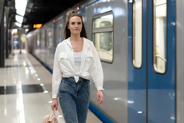 Avrupalı kız metro treni boyunca hızlı gidiyor, etrafta kimse yok. Kopyalama alanı için bol yer.