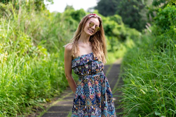 一个女孩走在一个绿色的公园里的石道上 年轻的欧洲人穿着长裙与大自然独处 一个人旅行 — 图库照片