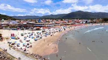 Florianpolis Santa Catarina Brezilya 'daki Barra da Lagoa Kanalı ve Plajı' nın havadan görünüşü. Güneşli bir yaz gününde turist ve şemsiyelerle dolu kumlar.