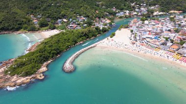 Florianpolis, Santa Catarina, Brezilya 'daki Barra da Lagoa kanalı ve plajı, tatlı suyun denizden tuzlu suyla buluştuğu kanalda kesiştiği iki tekne.