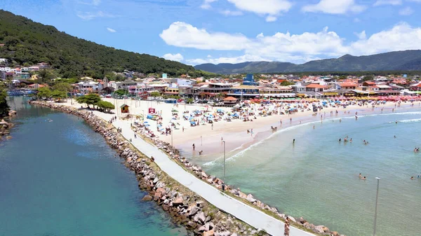 Florianpolis Santa Catarina Brezilya 'daki Barra da Lagoa Kanalı ve Plajı' nın havadan görünüşü. Güneşli bir yaz gününde turist ve şemsiyelerle dolu kumlar.