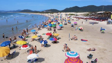 Joaquina Sahili 'nin havadan görünüşü, kumsalın ve denizin altında, güzel bir yaz günü Florianopolis, Santa Catarina, Brezilya' da insanlarla ve şemsiyelerle dolu..