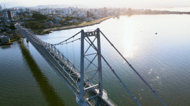 Hercilio Luz Köprüsü 'nün panoramik hava manzarası ve başkent Florianpolis' in merkezi bölgesi, Santa Catarina, Brezilya. Güneşli bir yaz gününde, güneş ışığı denizlere yansıyor.