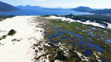 Florianpolis, Santa Catarina 'da bulunan Joaquina Sahili ve Lagoa da Conceio' daki Doğal Park Kumulları 'nın havadan görünüşü. Kum tarlaları, dinlenme bitkileri, ekolojik ve turistik göller.