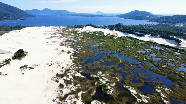 Florianpolis, Santa Catarina 'da bulunan Joaquina Sahili ve Lagoa da Conceio' daki Doğal Park Kumulları 'nın havadan görünüşü. Kum tarlaları, dinlenme bitkileri, ekolojik ve turistik göller.
