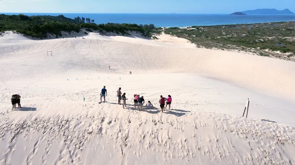 Florianpolis, Santa Catarina 'daki Joaquina Sahili' nin hava manzarası. İnsanlar kumda, kumsalda, sporda, kum tepeciklerinde, bitki örtüsünde, ekolojik ve turistik göllerde sörf yapıyor..