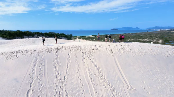 Florianpolis, Santa Catarina 'daki Joaquina Sahili' nin hava manzarası. İnsanlar kumda, kumsalda, sporda, kum tepeciklerinde, bitki örtüsünde, ekolojik ve turistik göllerde sörf yapıyor..