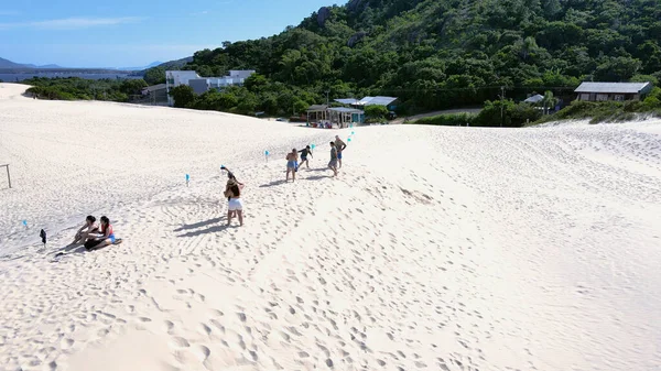 Florianpolis, Santa Catarina 'daki Joaquina Sahili' nin hava manzarası. İnsanlar kumda, kumsalda, sporda, kum tepeciklerinde, bitki örtüsünde, ekolojik ve turistik göllerde sörf yapıyor..