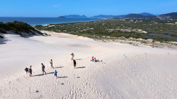 Florianpolis, Santa Catarina 'daki Joaquina Sahili' nin hava manzarası. İnsanlar kumda, kumsalda, sporda, kum tepeciklerinde, bitki örtüsünde, ekolojik ve turistik göllerde sörf yapıyor..
