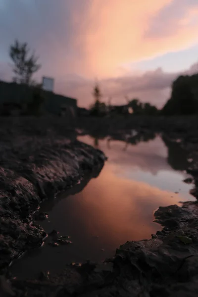 Smuts landsbygd väg på våren efter regn mot solnedgång bakgrund — Stockfoto