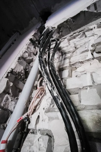 Duvardaki elektrik kablolarının tamamlanmamış kurulumu yeni bina binası.