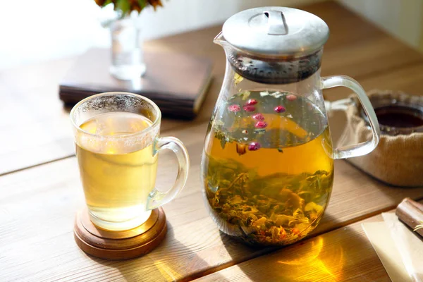 Traditioneller Kräutertee mit Glasteekanne, Tasse, getrockneten Rosenknospen. Blumen auf Holztisch zu Hause, Sonnenlicht Hintergrund, selektiver Fokus, Kopierraum — Stockfoto