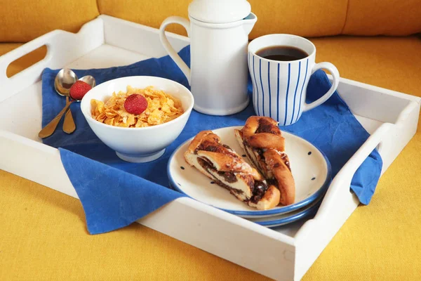 Богатый континентальный завтрак на белой деревянной табличке и желтом диване. Французские кукурузные хлопья, мюсли, сладкие ягоды и горячий кофе для вкусных утренних блюд. Вкусное начало дня . — стоковое фото