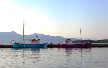 Sudaki tekneler - Korfu Kerkyra kasabası ve güneşli bir günde mavi gökyüzü. Anemomilos bölgesindeki tatil konsepti, Korfu Adası, İyon adaları, Yunanistan. Boş Korfu adası.