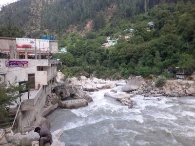 Neelum Vadisi 'nin pitoresk Kundal Shahi bölgesinde hızla akan bir şelalenin çarpıcı gündüz manzarası..
