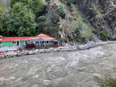 Neelum Vadisi 'nin pitoresk Kundal Shahi bölgesinde hızla akan bir şelalenin çarpıcı gündüz manzarası..