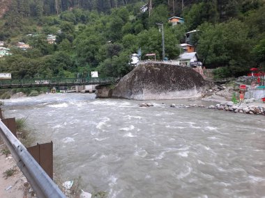 Neelum Vadisi 'nin pitoresk Kundal Shahi bölgesinde hızla akan bir şelalenin çarpıcı gündüz manzarası..