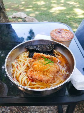 Büyük bir porsiyon baharatlı miso ramen dilimli tavuk katsu ve paslanmaz kase.