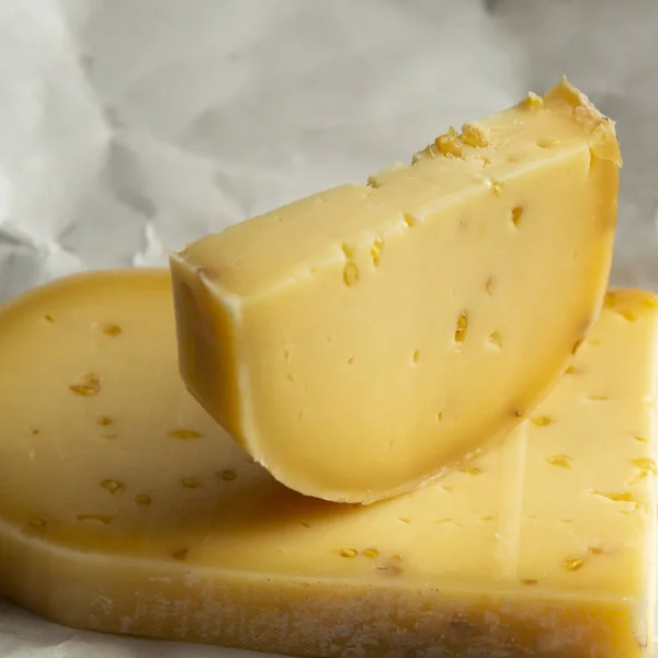 Pedazo de queso de vaca con semillas de alholva hecho en la abadía belga b —  Fotos de Stock