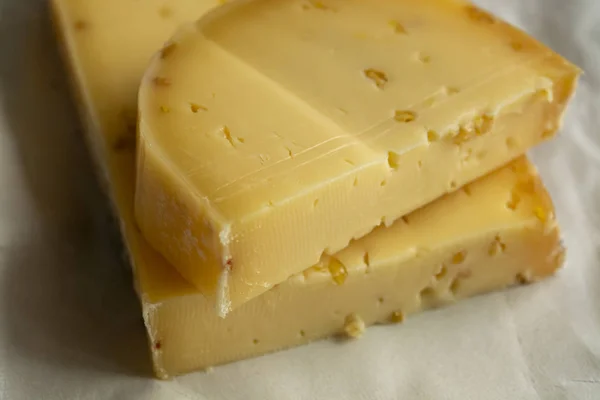 Piece of cow cheese with fenugreek seeds made in Belgian abbey b — Stock Photo, Image