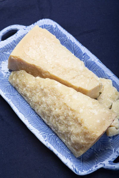 Italian original aged Parmesan cheese in two pieces served on bl