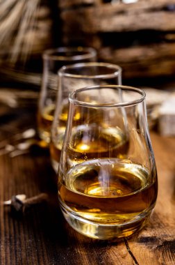 Speyside viskisi. Arpa tanecikli eski siyah ahşap şarap masasında tadıyor.