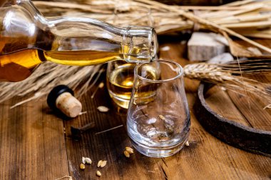 Speyside viskisi. Arpa tanecikli eski siyah ahşap şarap masasında tadıyor.