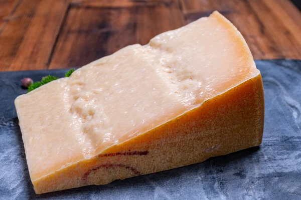 パルミジャーノ レッジャーノ パルメザン ハードの大きなくさび牛乳やグラナパダーノから作られたイタリアのチーズを閉じます — ストック写真