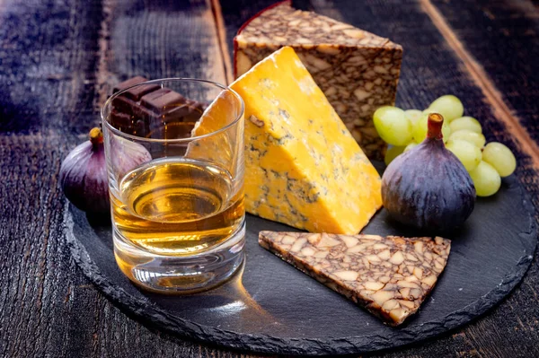 Tasting of Irish blended whiskey and cheeses from Ireland and UK, dark background