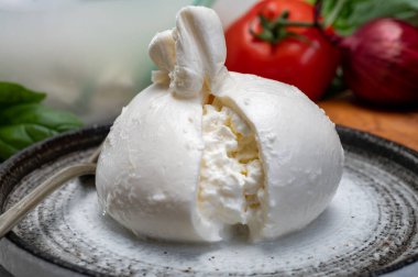 Puglia 'dan taze el yapımı İtalyan peyniri yemek, beyaz burrata topları veya mozzarella ve kremadan yapılmış burratina peyniri yemek.