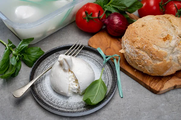 Puglia 'dan taze el yapımı İtalyan peyniri yemek, beyaz burrata topları veya mozzarella ve kremadan yapılmış burratina peyniri yemek.