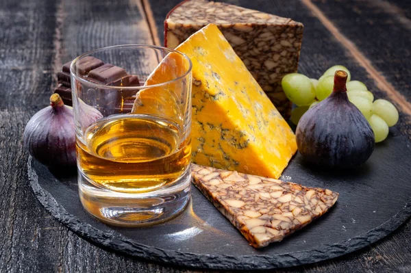 Tasting of Irish blended whiskey and cheeses from Ireland and UK, dark background