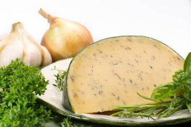 İnek sütünden yapılmış Hollanda özel sert peyniri farklı baharatlar ve taze yeşil otlar.