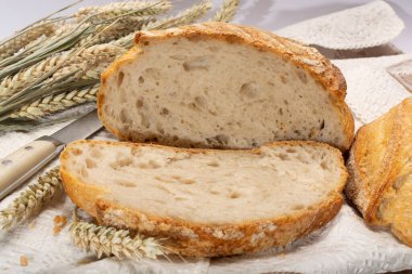 Ekşi hamurlu, yuvarlak, beyaz buğday ekmeği. Dilimler yakın.