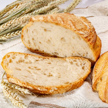 Ekşi hamurlu, yuvarlak, beyaz buğday ekmeği. Dilimler yakın.