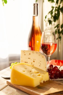 Hollanda sert peyniri Maasdam ya da Emmentaler, delikli peynir ve gül şarabıyla servis edilen kişniş soslu sert keçi peyniri.