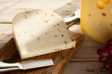 Hollanda sert peyniri Maasdam veya Emmentaler, delikli peynir ve kişniş aromalı sert keçi peyniri.