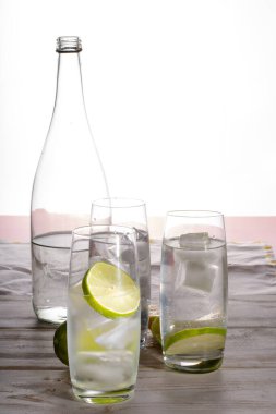 Cam şişede üç bardak buzlu, limonlu ve limonlu soda.