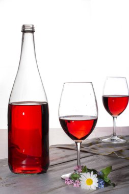 İki bardak ve çiçekle servis edilen gül şarabı kopyalama alanını kapat.