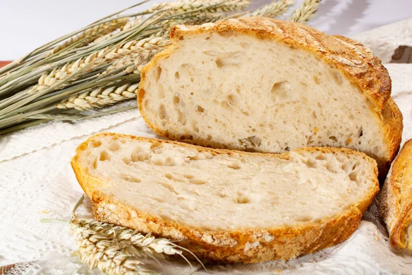 Ekşi hamurlu, yuvarlak, beyaz buğday ekmeği. Dilimler yakın.