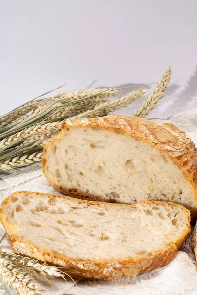 Ekşi hamurlu, yuvarlak, beyaz buğday ekmeği. Dilimler yakın.