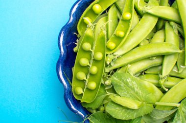 Taze yeşil şekerleme, tatlı bezelyeler kasede fotokopi alanı mavi arkaplanı kapatın.