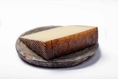 Bir parça İspanyol sütlü peyniri. Gri taş tabakta Manchego, izole edilmiş olarak kapat.