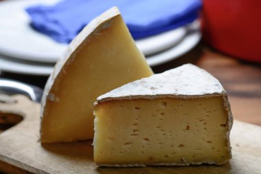 Fransız Tomme ve Cantal peyniri parçaları, yakın plan.