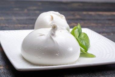 Fresh soft white burrata, ball buttery cheese, made from a mix of mozzarella and ricotta cream, original from Apulia region, Italy, very popular soft cheese in USA clipart