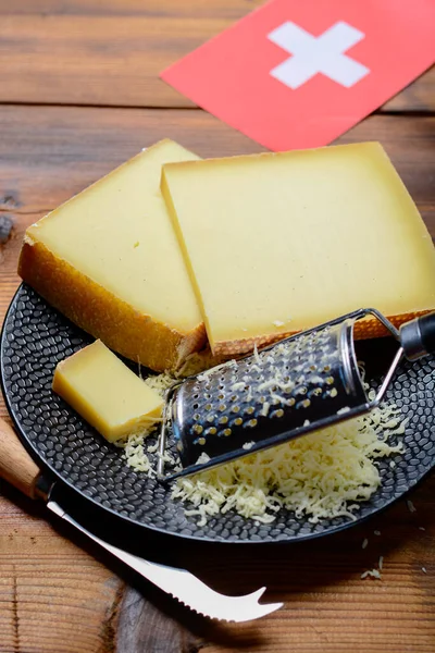 スイスチーズの盛り合わせ伝統的なチーズフォンデュやグラタン スイスの国旗に使われる丸みを帯びた穴 グリュイエール アペンセラー ラクレットを持つメンタルまたはエメンタール中ハードチーズ — ストック写真