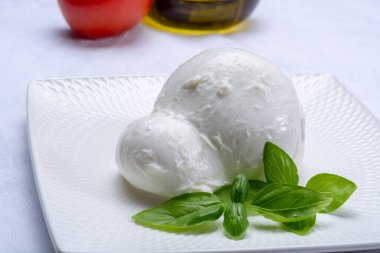 Güney İtalya 'nın Campania, Paestrum ve Foggia bölgelerinden gelen taze İtalyan peynirli mozzarella bufalosu domates, taze fesleğen ve zeytinyağı ile servis edilir.